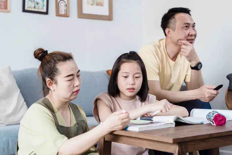 A parent sitting with a child, reviewing a completed practice paper together, illustrative photo